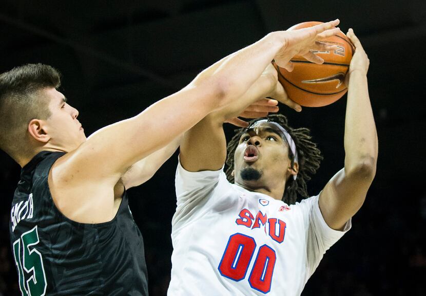 SMU forward Ben Moore (00) puts up a shot as Tulane center Ryan Smith (15) defends during...
