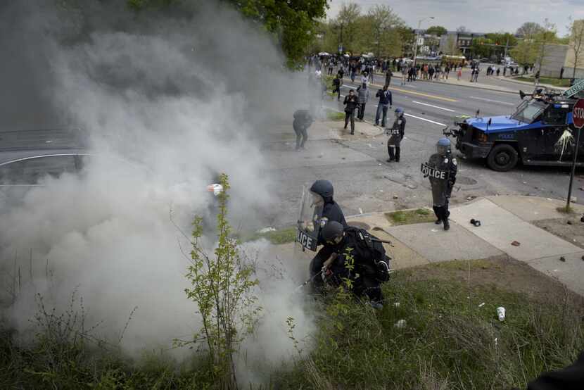 Police put out a fire caused by a teargas canister April 27, 2015 in Baltimore, Maryland....