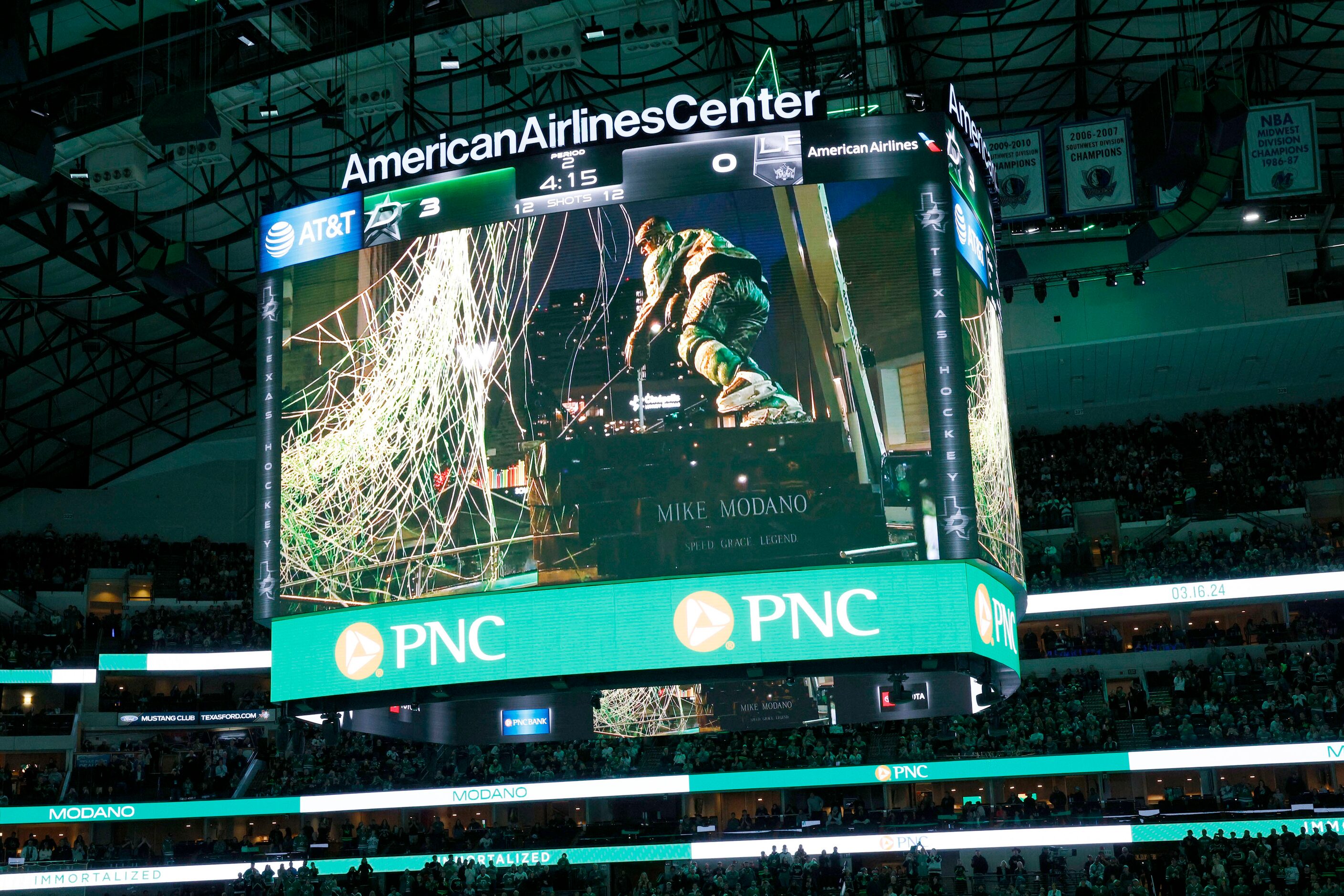 A big screen shows Dallas Stars legend Mike Modano’s statue during the unveiling ceremony of...