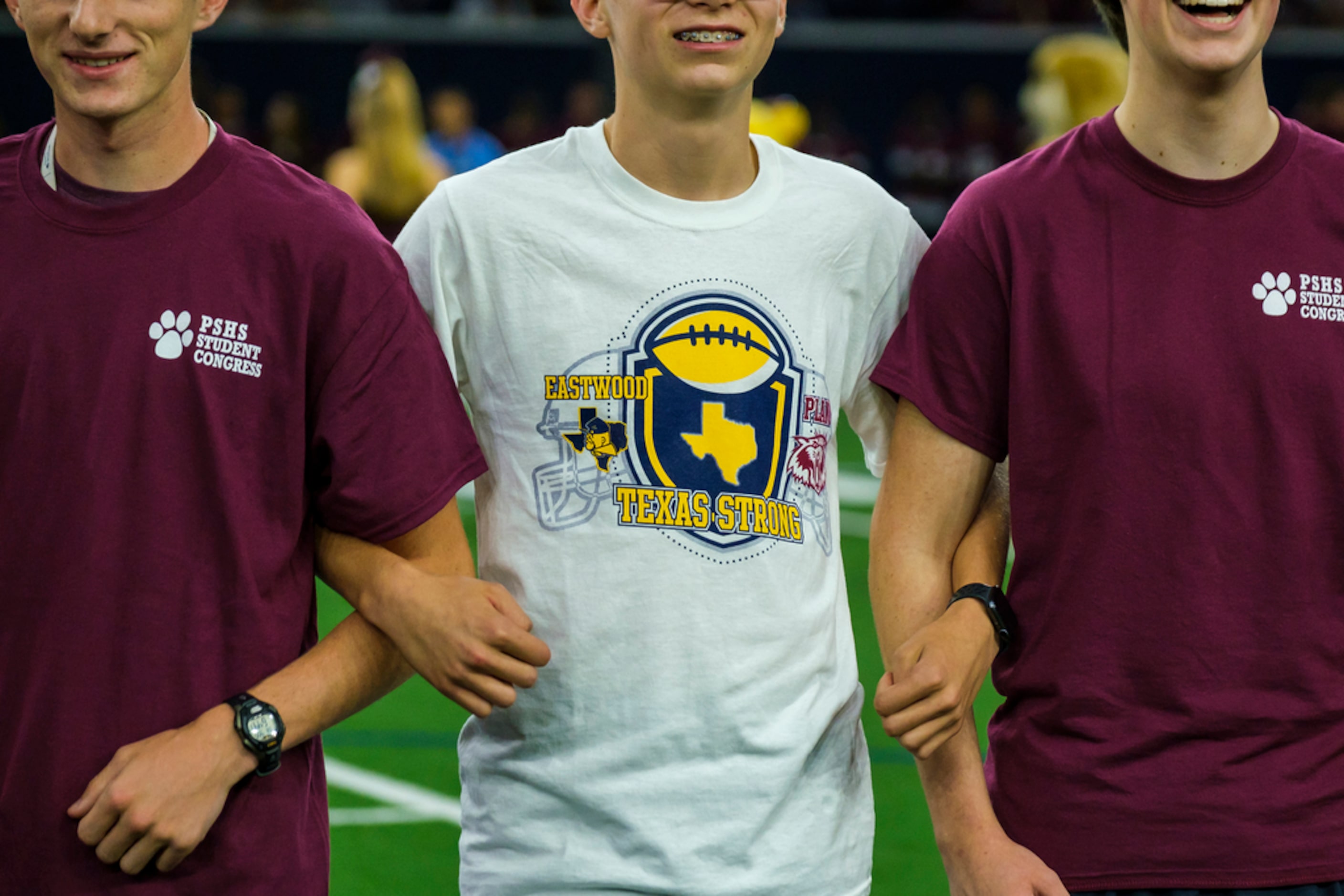 Student government representatives from Plano and El Paso Eastwood High Schools lock arms as...