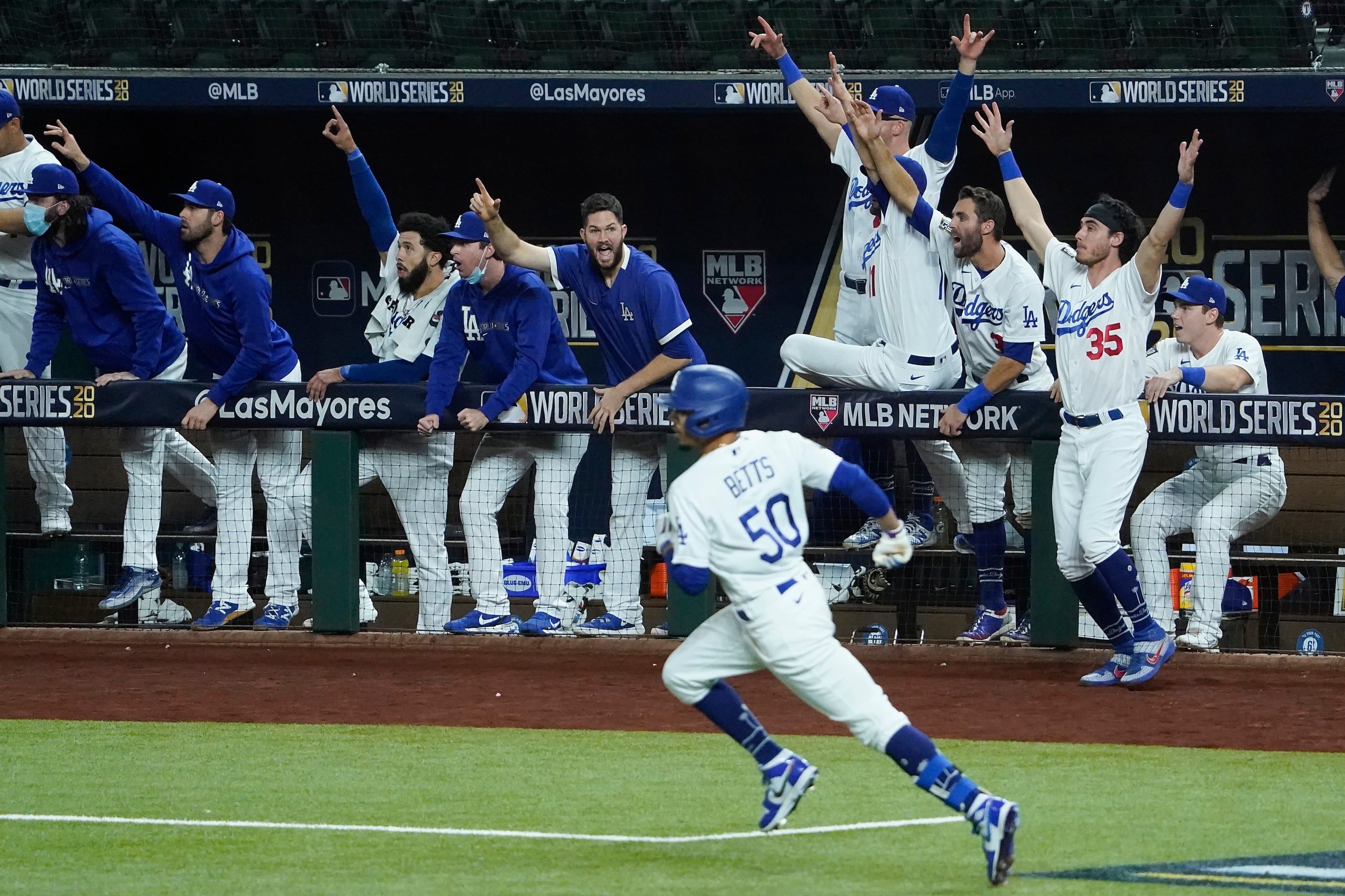 The Los Angeles Dodgers dugout erupts after right fielder Mookie Betts (50) hit a solo home...