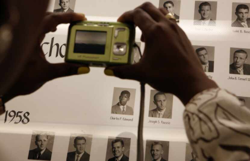 Nedra Grisby photographs a picture of Charles Edmond, the first black student to graduate...