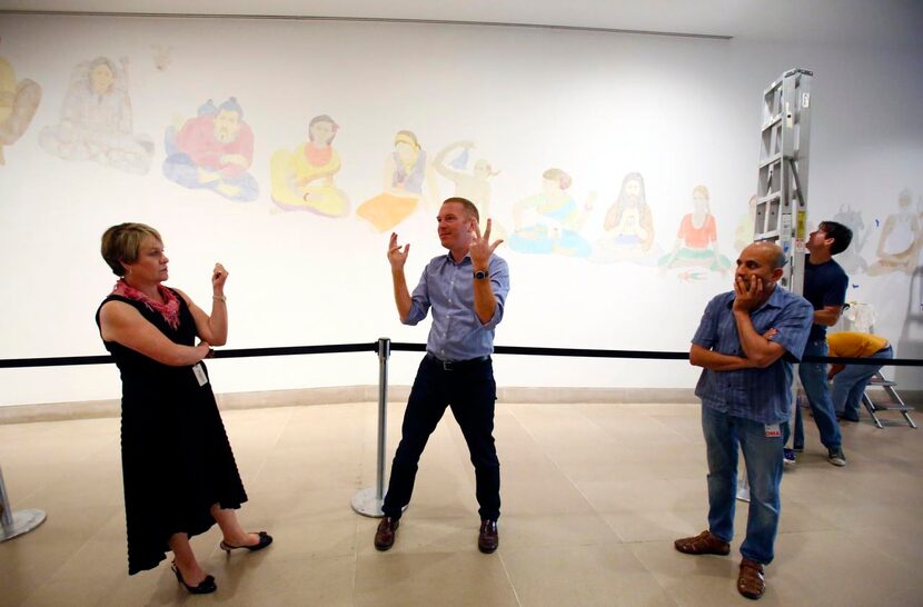 
Artist NS Harsha (right) stands in front of his mural, “Sprouts, reach in to reach out.” 
