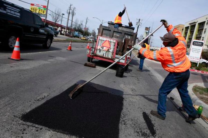 Gary Langley (right) and other Dallas city workers repair potholes on Lemmon Avenue in 2010.