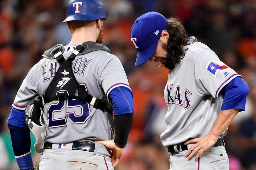 Texas Rangers relief pitcher Tony Barnette, right, looks down before being removed from the...