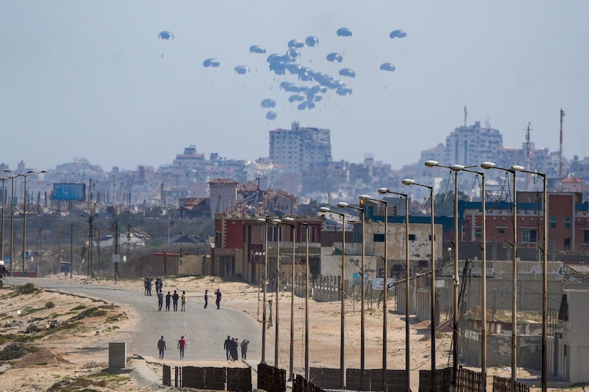 An aircraft airdrops humanitarian aid over the northern Gaza Strip, as seen from central...