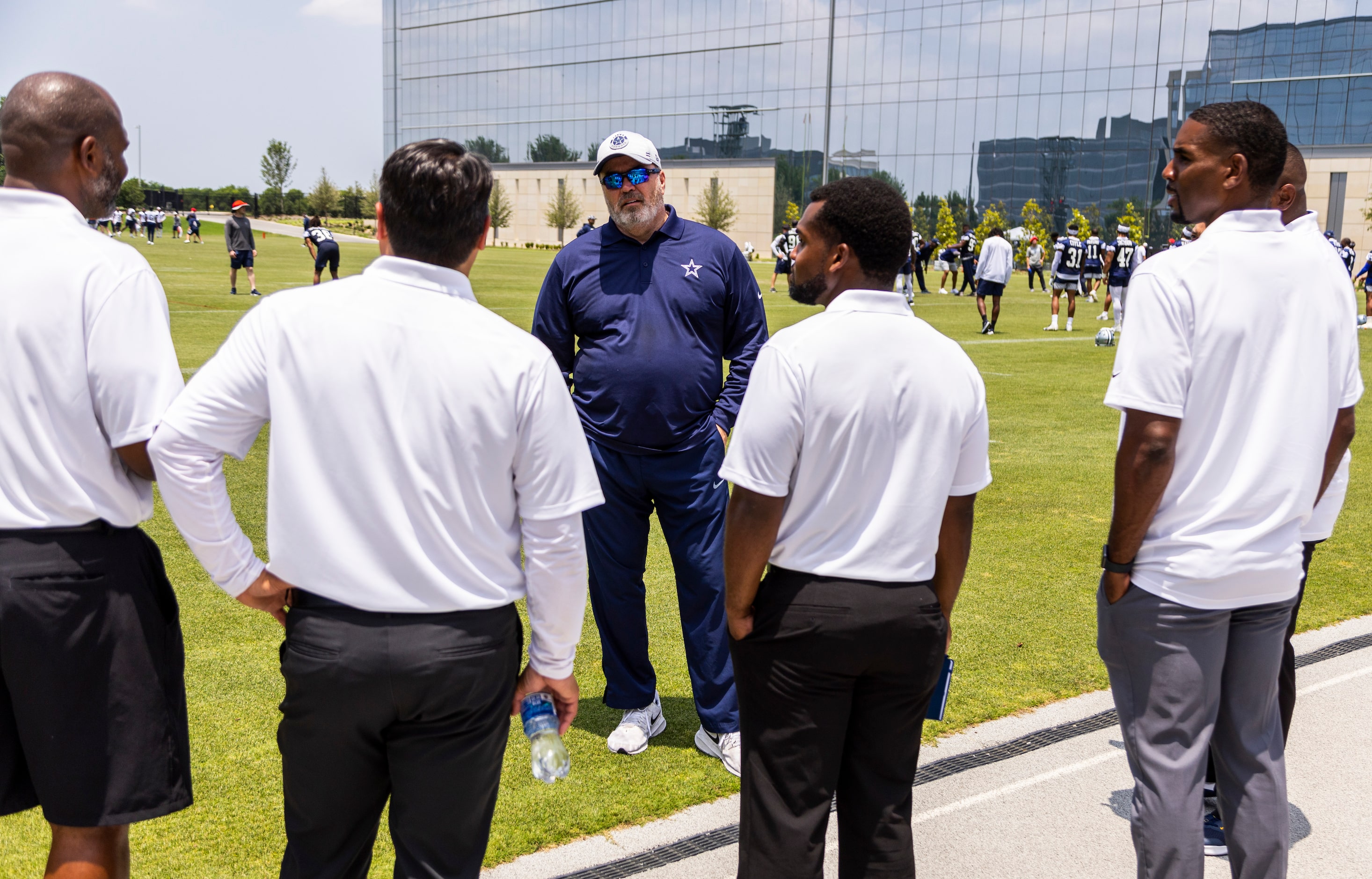 Dallas Cowboys head coach Mike McCarthy, center, speaks with Texas high school football...