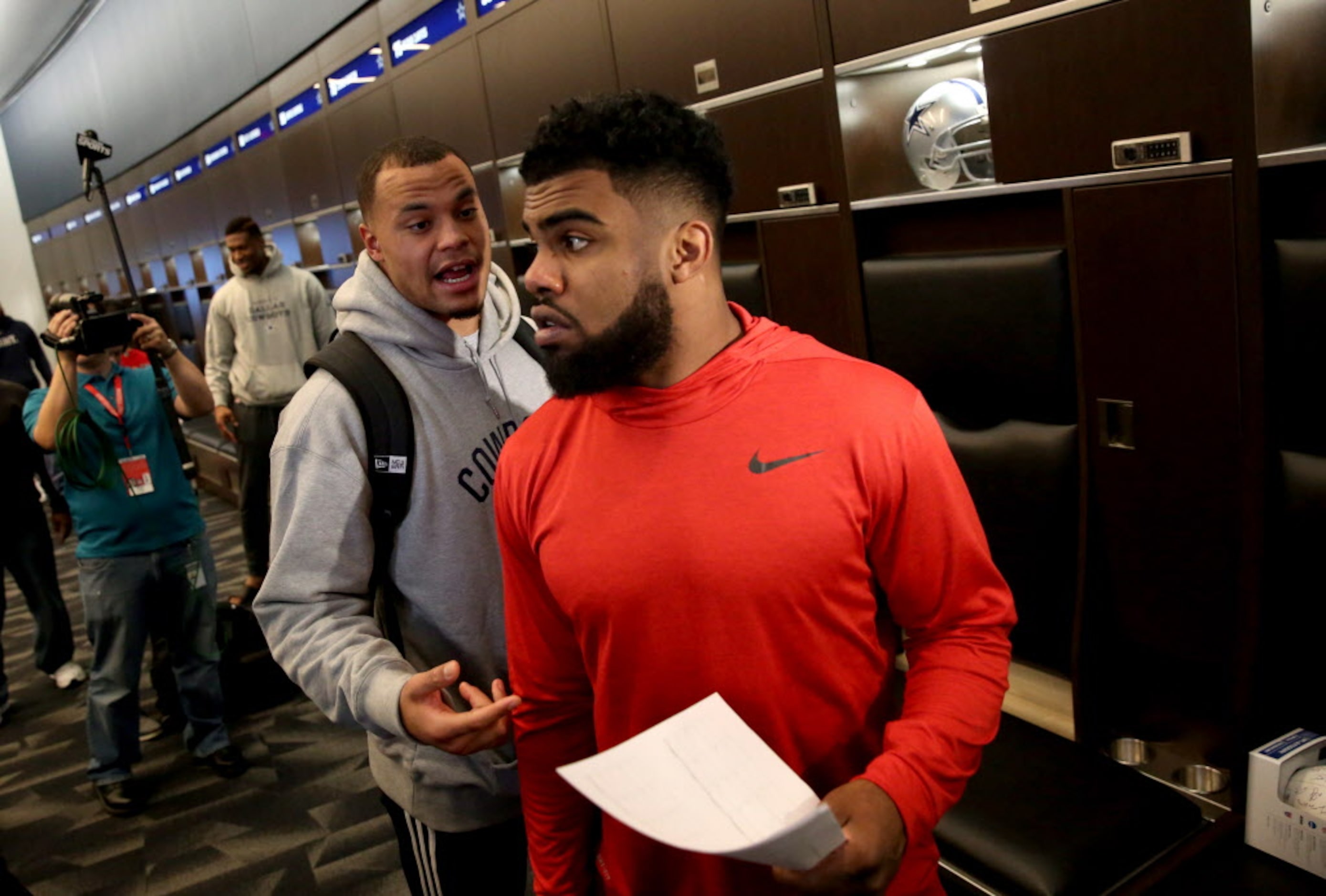 Dallas Cowboys quarterback Dak Prescott talks to running back Ezekiel Elliott during locker...