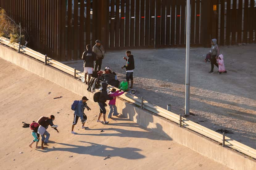 Migrants cross the Rio Grande river and US-Mexico border into El Paso, Texas as seen from...