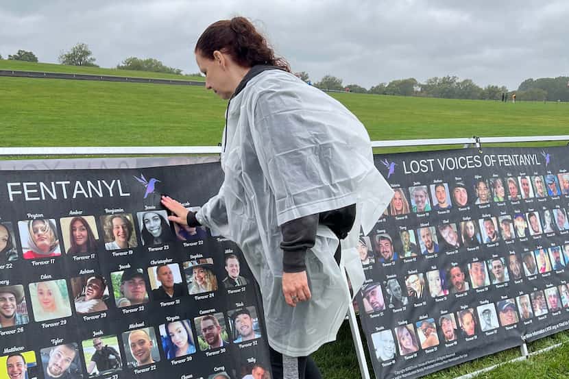 Jeri Horton of Plano brushes rain from her daughter Jessie's photo on a banner at the Lost...
