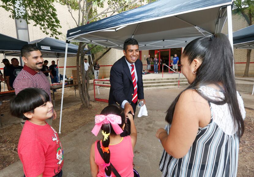 Teacher Adan Gonzalez greets a family at Bowie Elementary School in Dallas on Aug. 26, 2016....