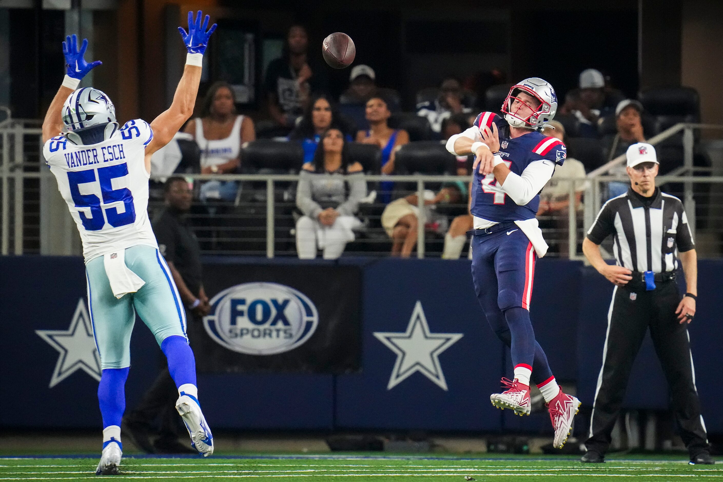 New England Patriots quarterback Bailey Zappe (4) throws a pass under pressure from Dallas...