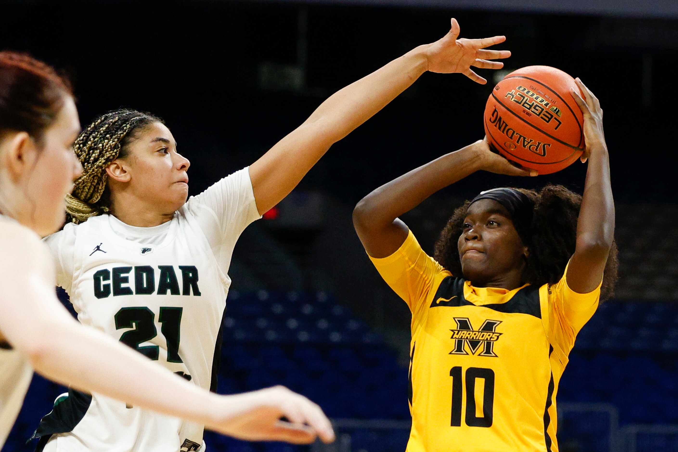 Cedar Park guard Gisella Maul (21) contests a shot from Frisco Memorial guard Jasmyn Lott...