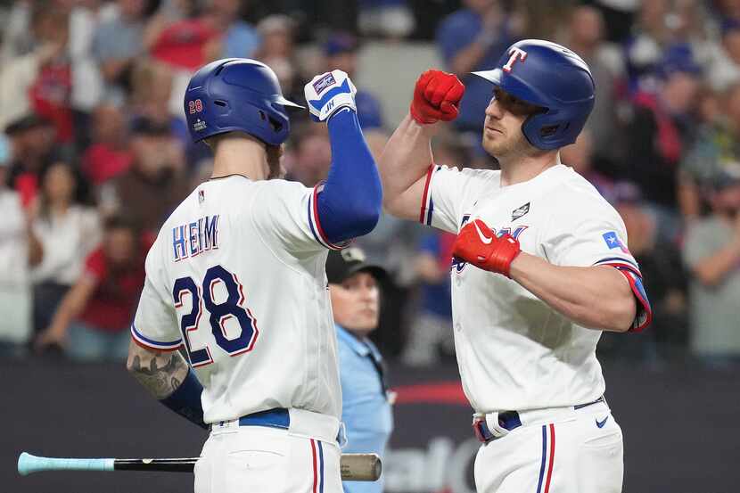 Texas Rangers designated hitter Mitch Garver, right, celebrates with Jonah Heim after hiting...