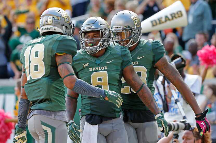 Baylor cornerback Ryan Reid (9) celebrates with safeties Chance Waz (18) and Orion Stewart...