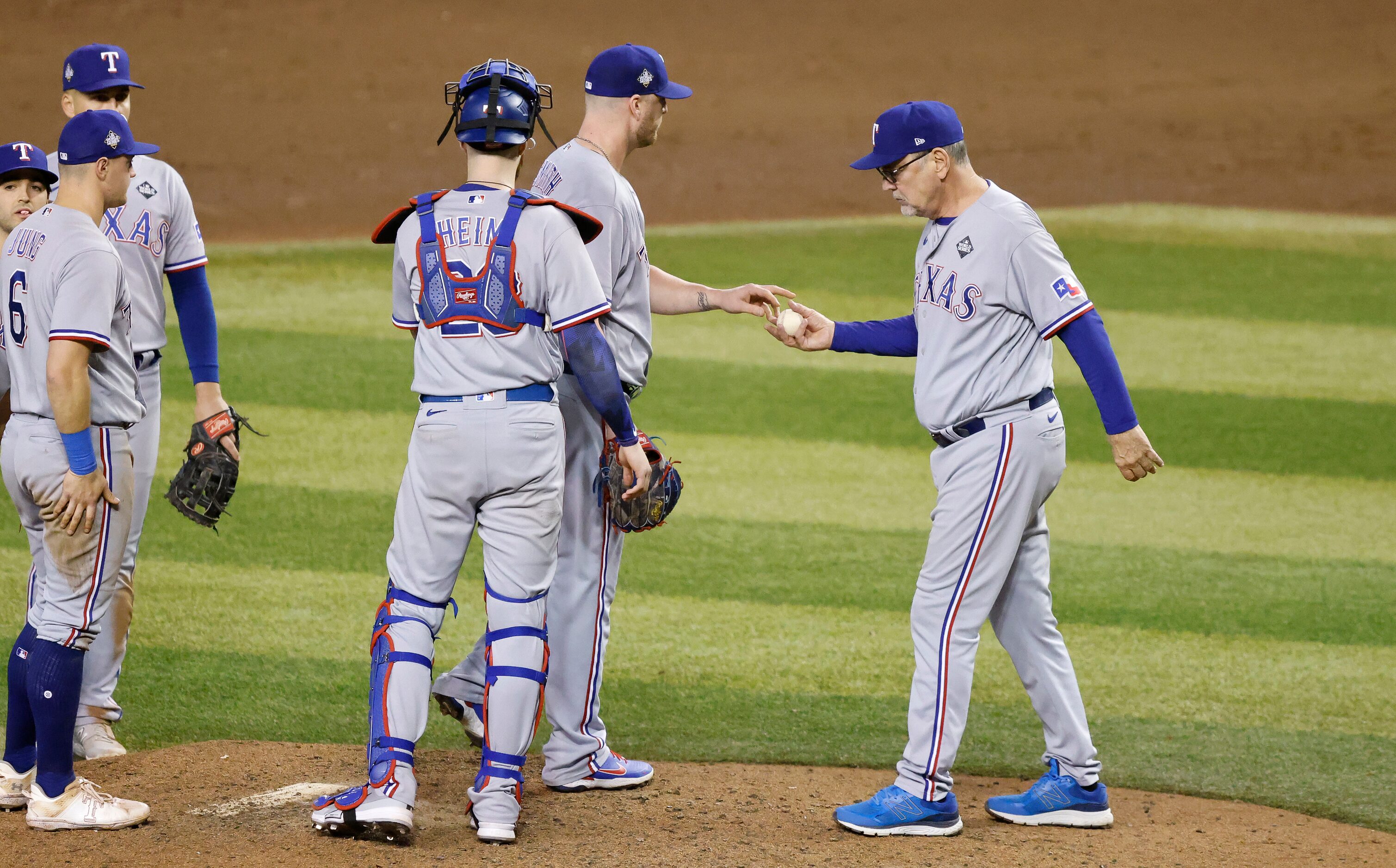 Texas Rangers manager Bruce Bochy (right) takes the ball from relief pitcher Will Smith...