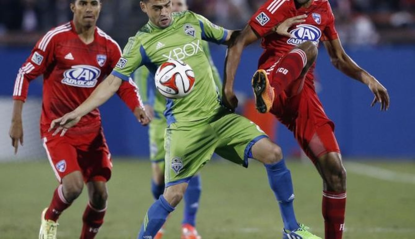 Lamar Neagle (centro) de Seattle disputa el balón con Tesho Akindele (der.) de Dallas en el...