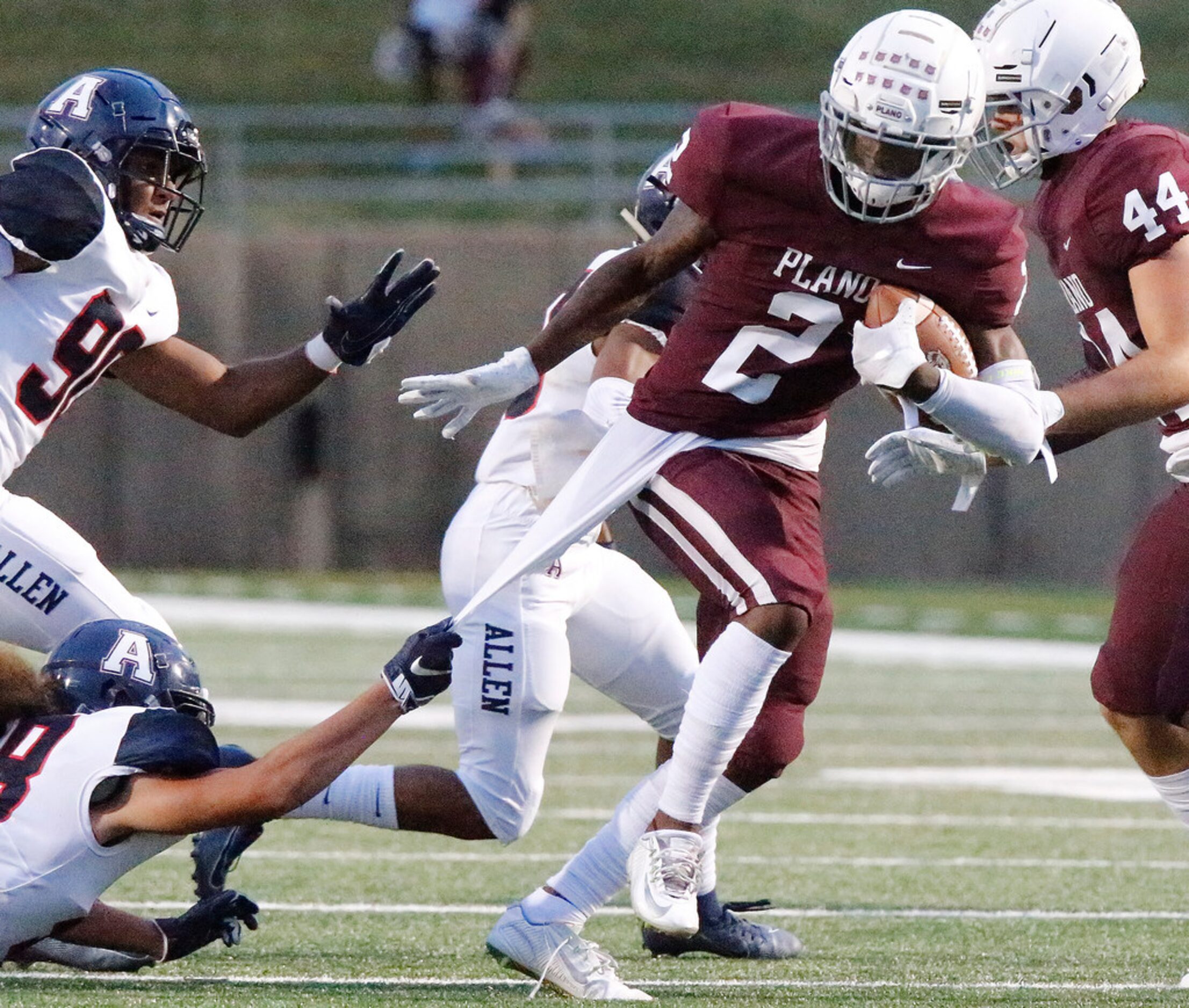 Allen High School linebacker Levi Tupou (48) hands onto the base layer of Plano High School...