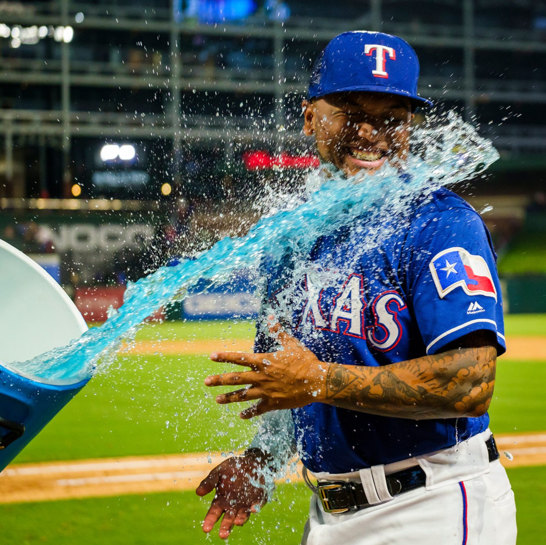 Texas Rangers left fielder Willie Calhoun is doused by second baseman Rougned Odor (12) ...