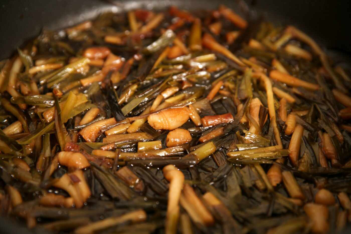 Wild onions are prepared in a skillet in the kitchen at Dallas Indian Mission United...