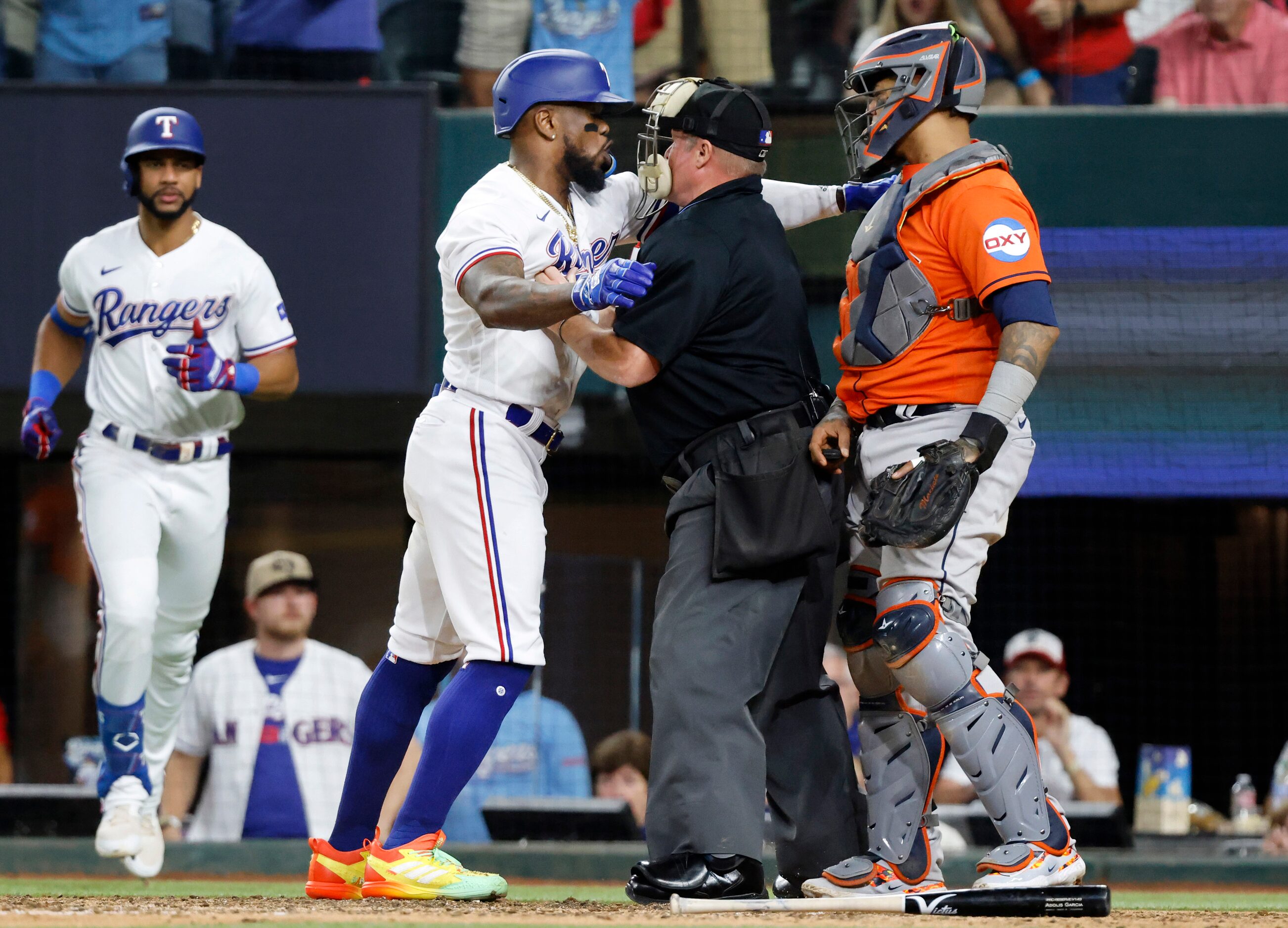 Homeplate umpire Marvin Hudson gets between Texas Rangers batter Adolis Garcia (53) and...