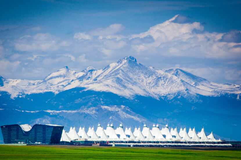 The Jeppesen Terminal at Denver International Airport with the Rocky Mountains behind it.