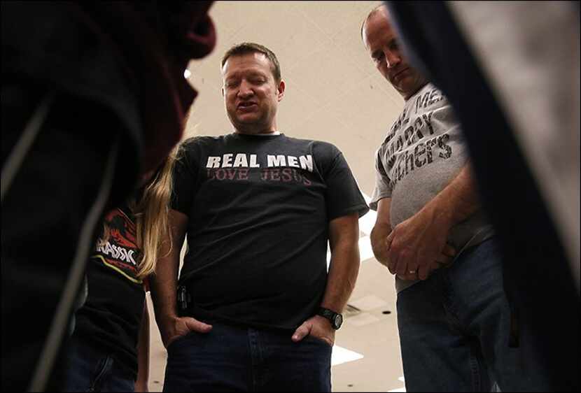 
Paul Raack (center) and Larry McGregor were part of a prayer circle at Monday’s vigil and...