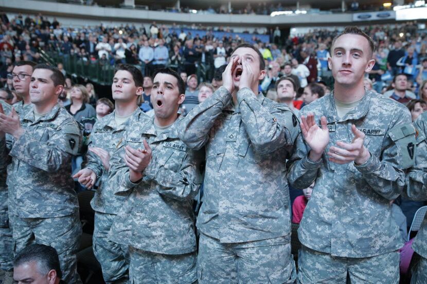 U.S. soldiers cheer from the front row before an NBA basketball game between the Milwaukee...