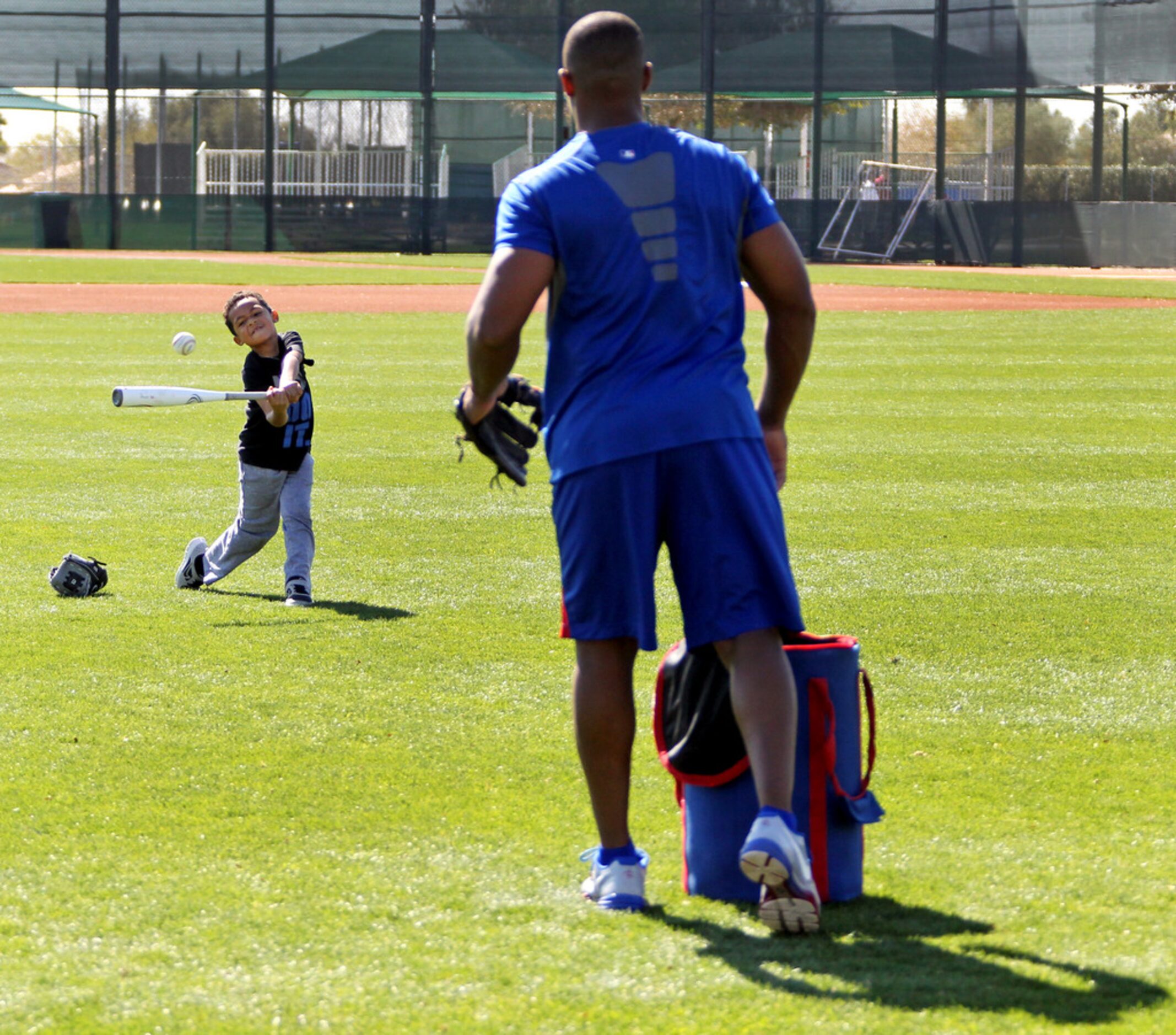 Texas Rangers third baseman Adrian Beltre pitches as his six-year-old son AJ Beltre takes...