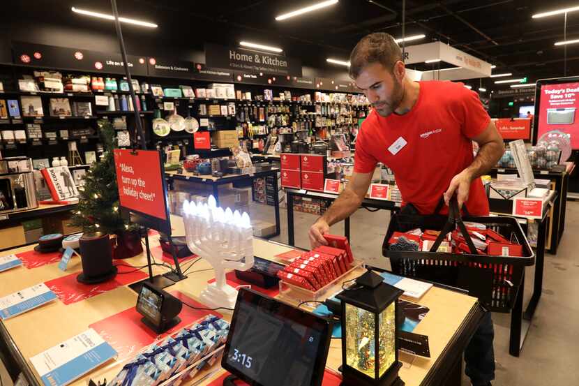Sab Mirzaei stocked a seasonal items table Tuesday in the Amazon 4-Star store at Stonebriar...