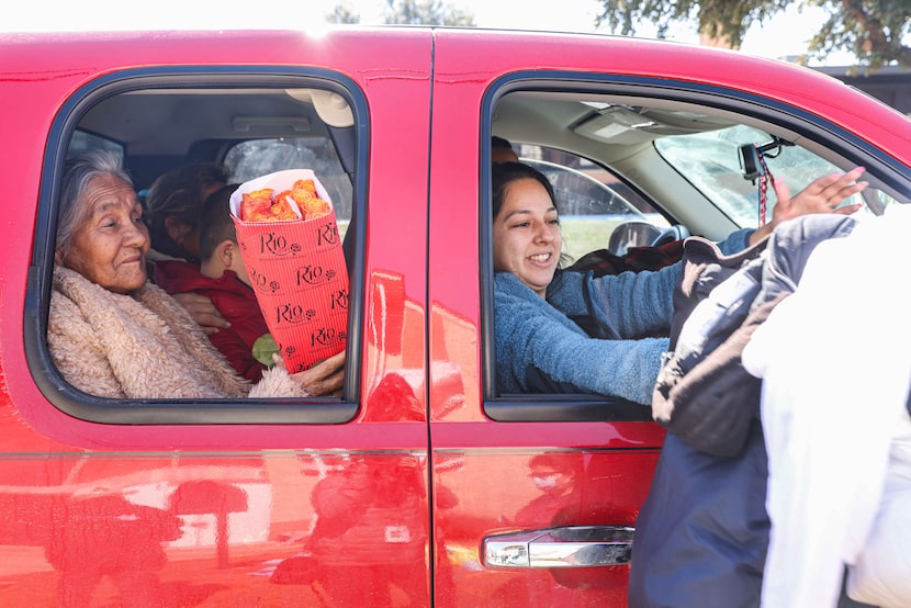 Guadale Lupe (left) and Yajaira Cantu picked up food from volunteers at Ledbetter Eagle Ford...