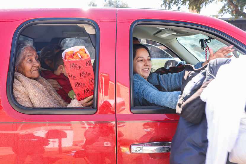 Guadale Lupe (left) and Yajaira Cantu picked up food from volunteers at Ledbetter Eagle Ford...