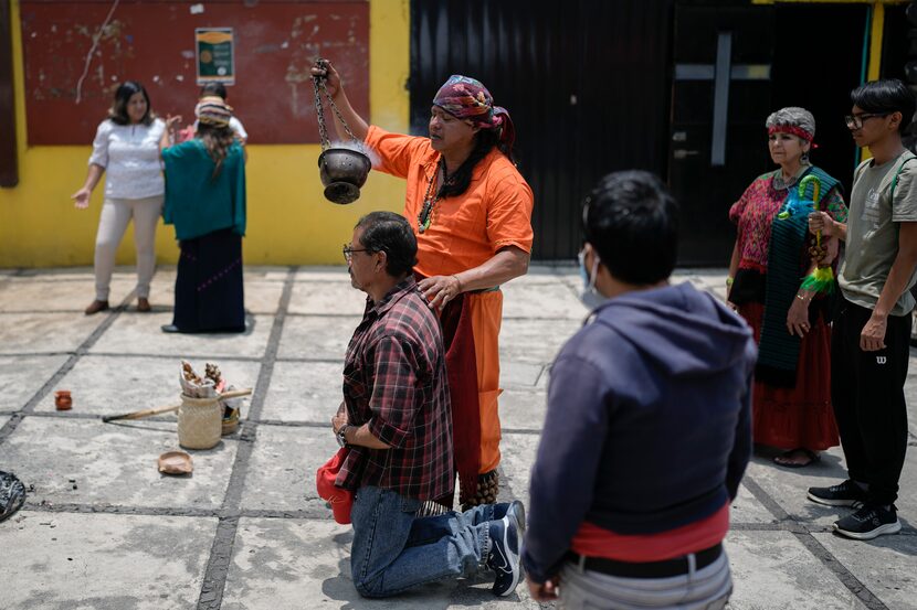 Residents and members of an Amaxac Indigenous organization use incense during a ceremony...