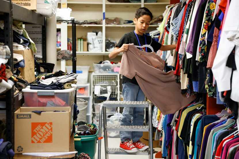 Asher Vargas, 9, organized clothes in a storage closet as he volunteered at Oak Lawn United...