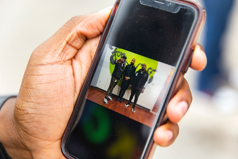 Taylor Toynes, executive director of For Oak Cliff, shows a photo he took with the late...