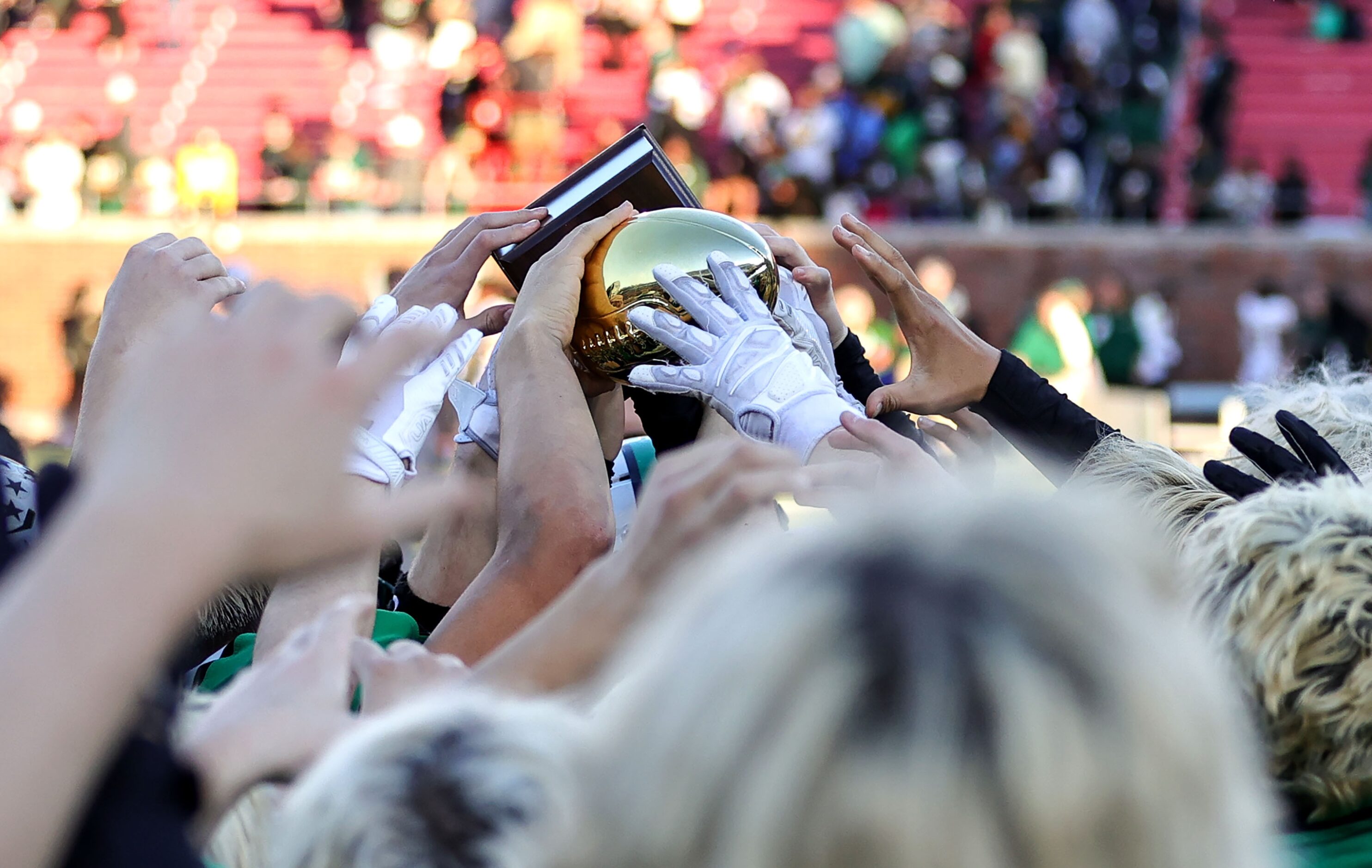 The Southlake Carroll Dragons hold their trophy after defeating Longview, 20-17 in a Class...