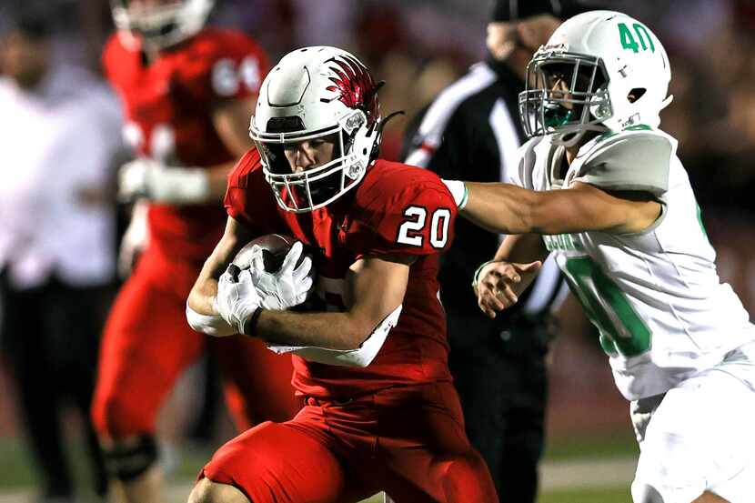Argyle running back Landon Farris (20) tries to fight his way for yardage against Lake...