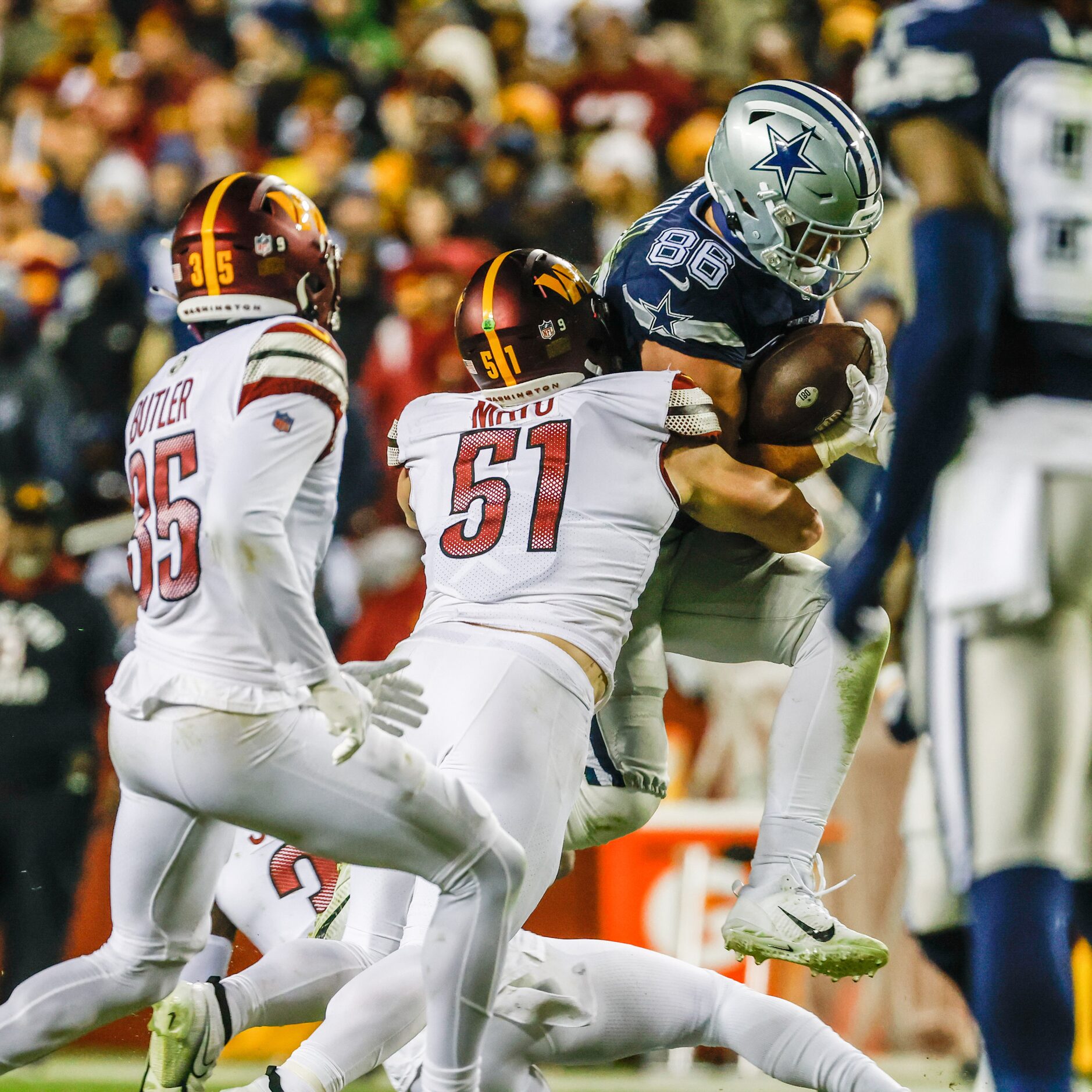 Dallas Cowboys tight end Dalton Schultz (86) jumps over Washington Commanders cornerback...