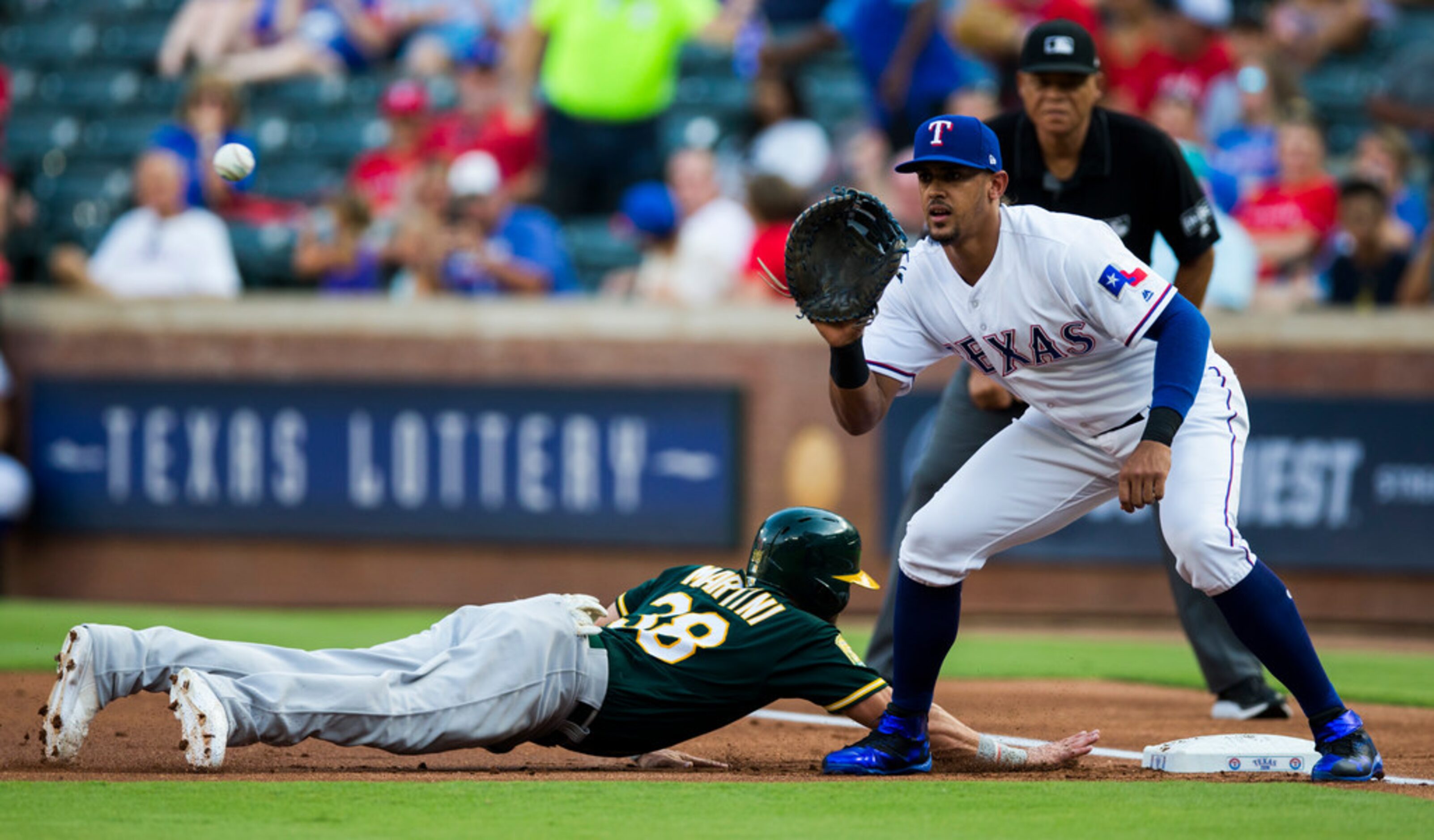 Texas Rangers first baseman Ronald Guzman (67) looks for a throw to first as Oakland...