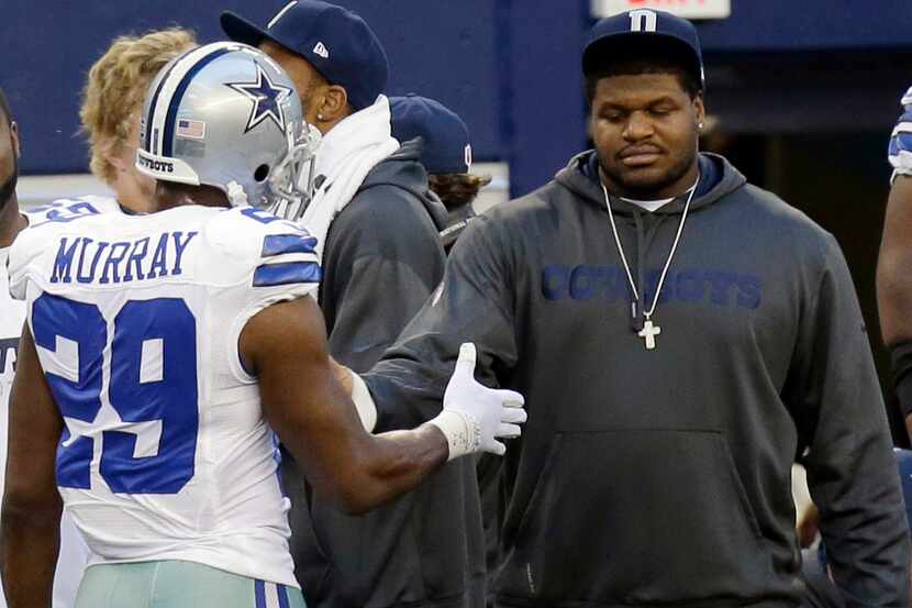 Dallas Cowboys suspended player Josh Brent, right, is greeted by DeMarco Murray (29) on the...