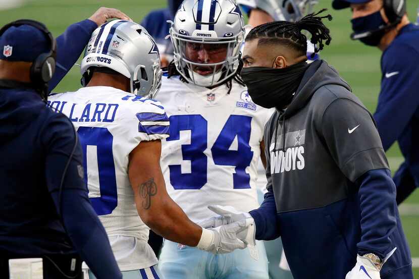 Injured Dallas Cowboys running back Ezekiel Elliott (right) congratulates fellow running...