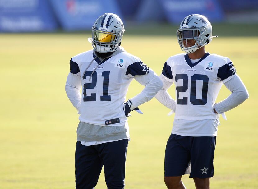 Cowboys running backs Ezekiel Elliott (21) and Tony Pollard (20) watch practice on the first...