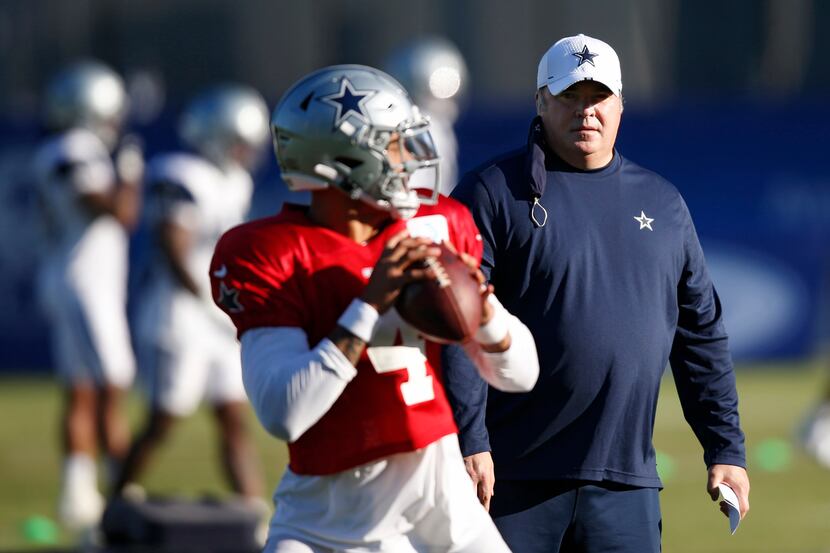 Cowboys head coach Mike McCarthy watches while quarterback Dak Prescott (4) runs through a...
