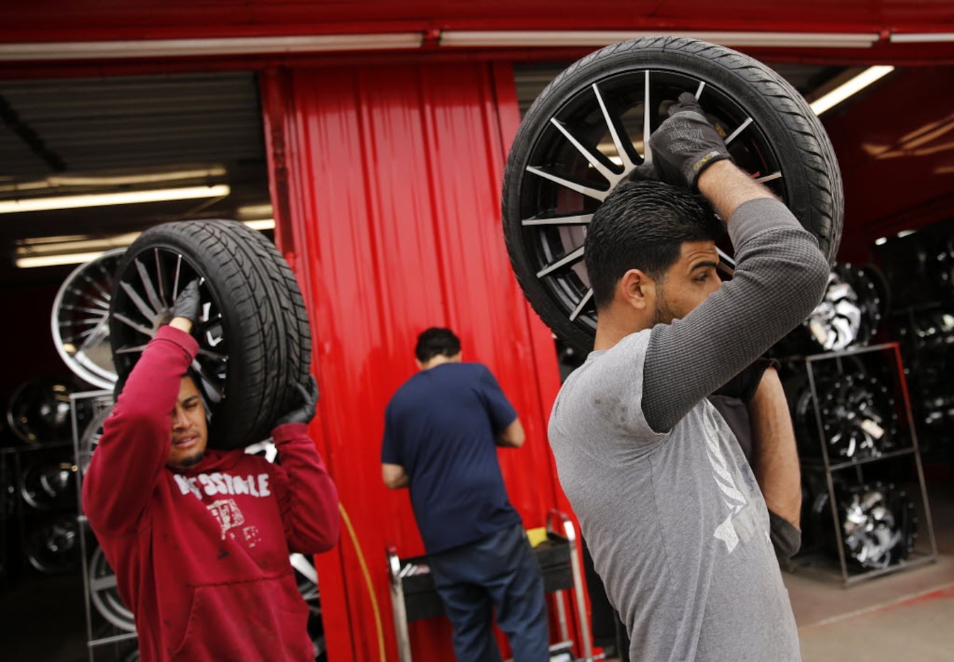 Danny Hossin (right) and Alex Ubaldo carry a set of tires to Mini Cooper after rebalancing...