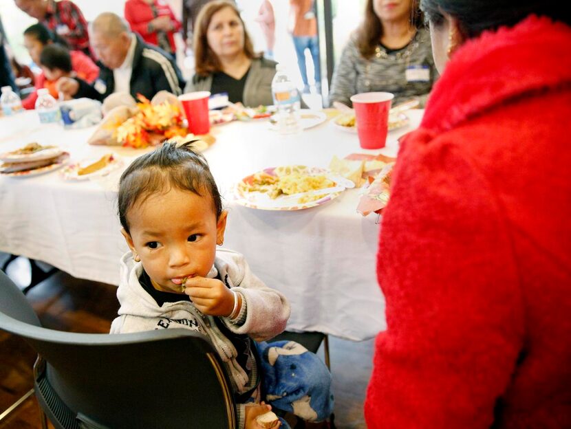 
One-year-old Andrew Magar chews on a green bean while checking out other diners at the...