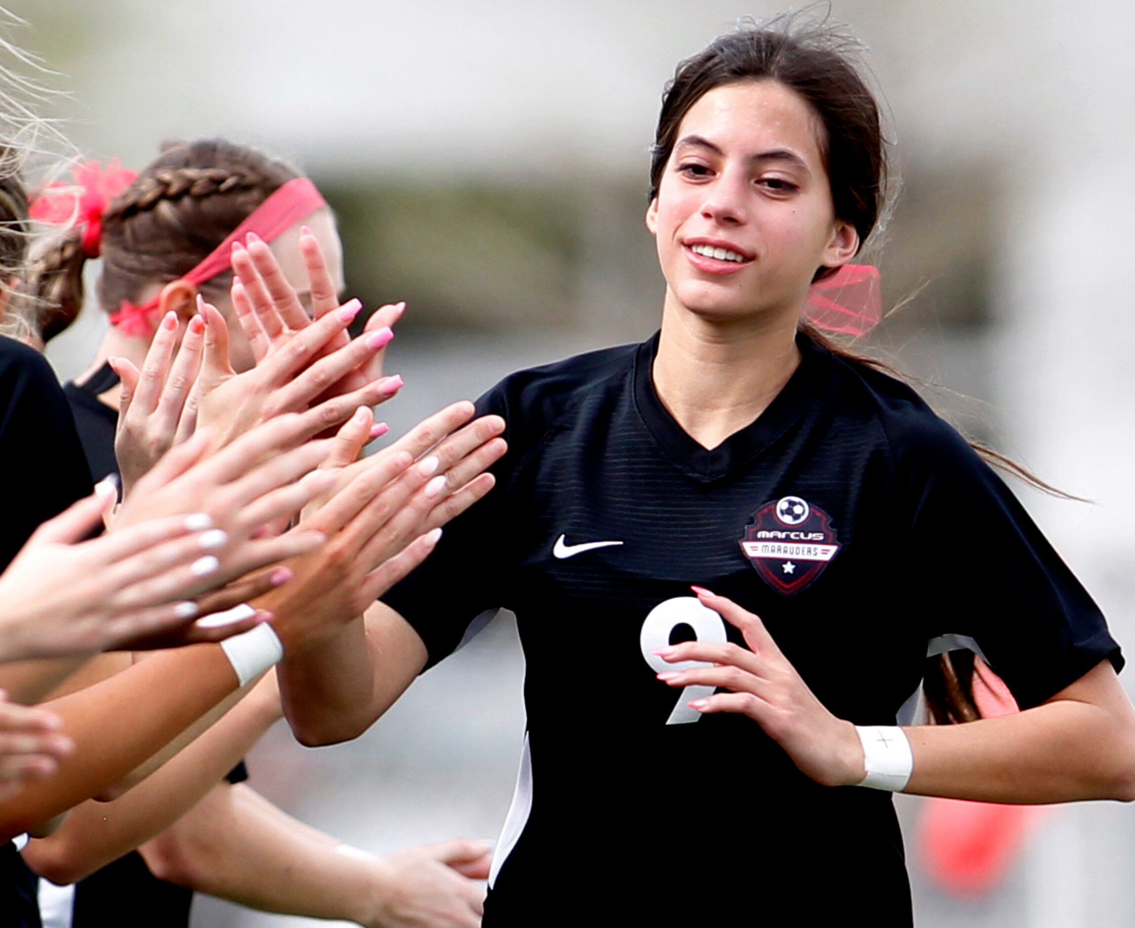 Flower Mound Marcus forward Maddie Hayes (9) is welcomed to the field by teammates during...