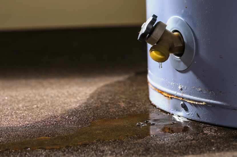 A low angle close-up view of water leaking from the plastic faucet on a residential electric...