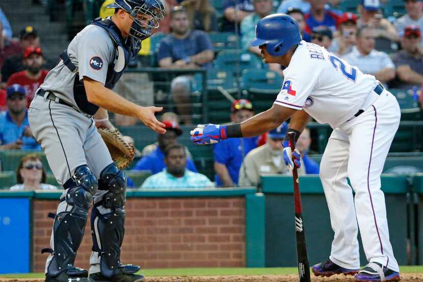 Texas Rangers third baseman Adrian Beltre (29) politely hands the ball to Detroit catcher...
