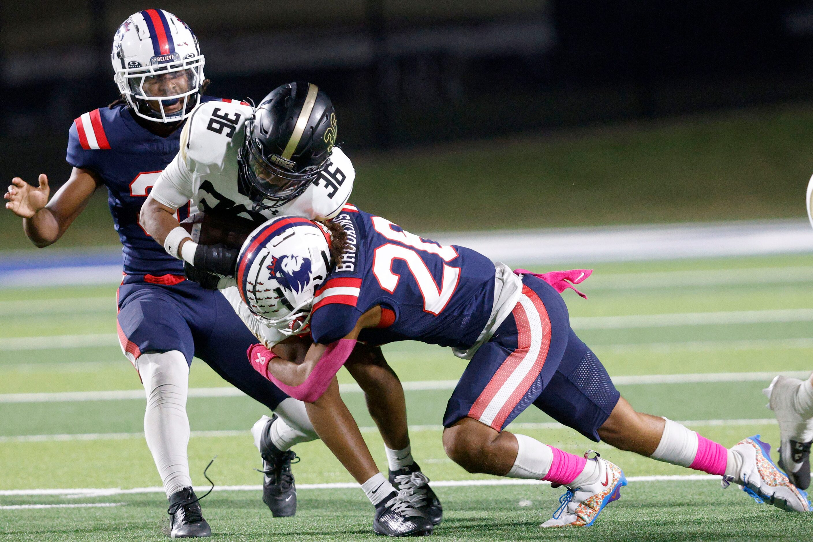 Fossil Ridge's Darnell Williams (36) is tackled by Richland's Isaiah Jefferson (31), left,...