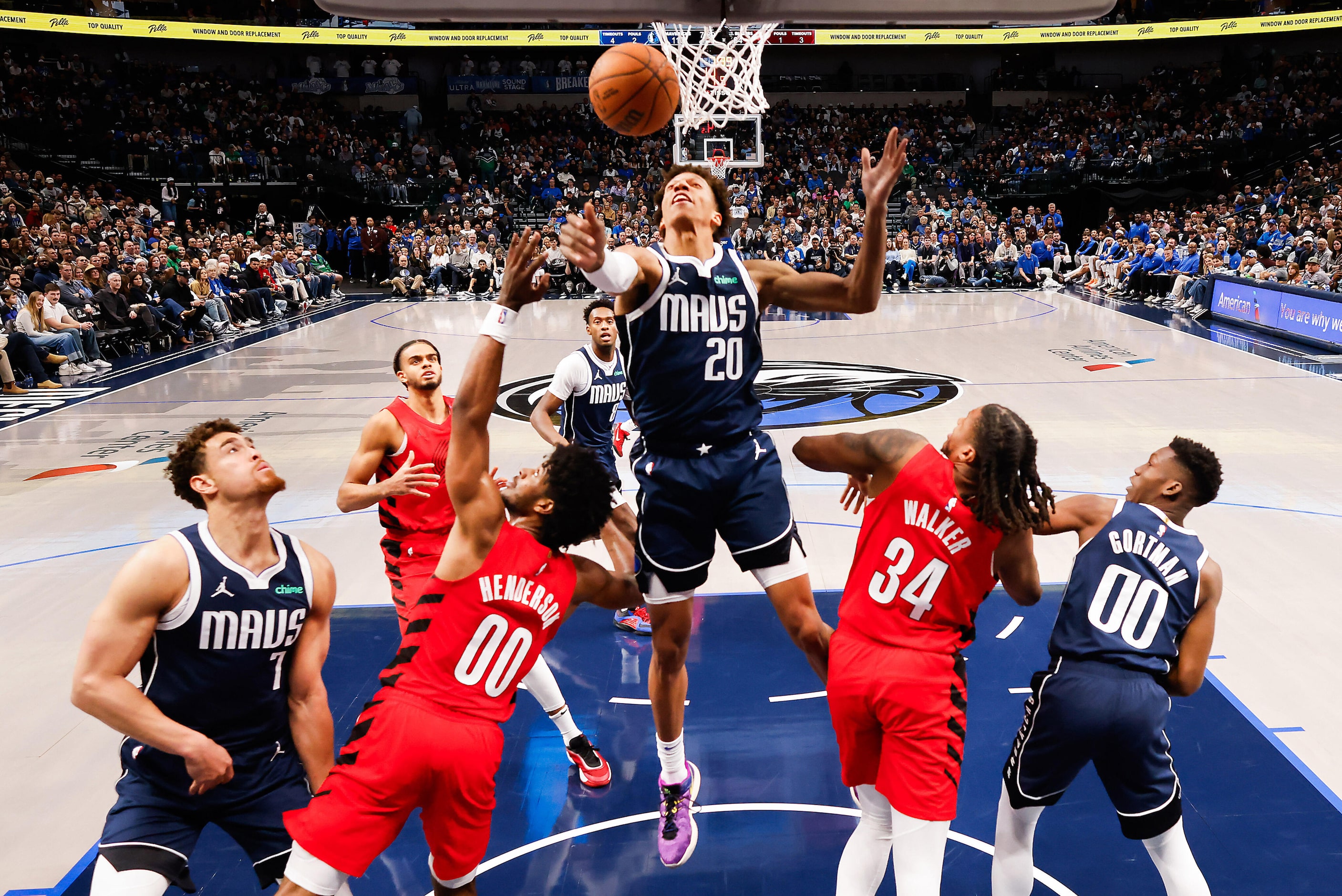 Dallas Mavericks forward Kessler Edwards (20) reaches for a rebound over Portland Trail...